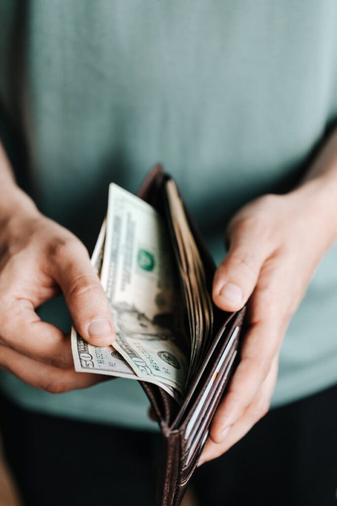 Photo by Karolina Kaboompics Crop man getting dollars from wallet
